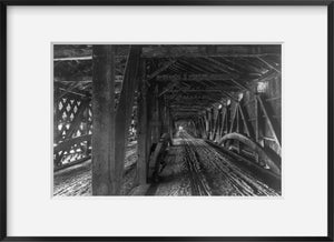 Photo: Covered bridge from inside, c1904, wood beams, cables, dirt road