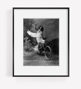 Photo: Queen of the wheel, c1897, woman sitting on bicycle, glass of wine