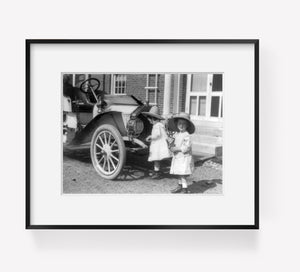 Photo: Small twin girls in front of 1911 Buick roadster, wearing straw hats, glass