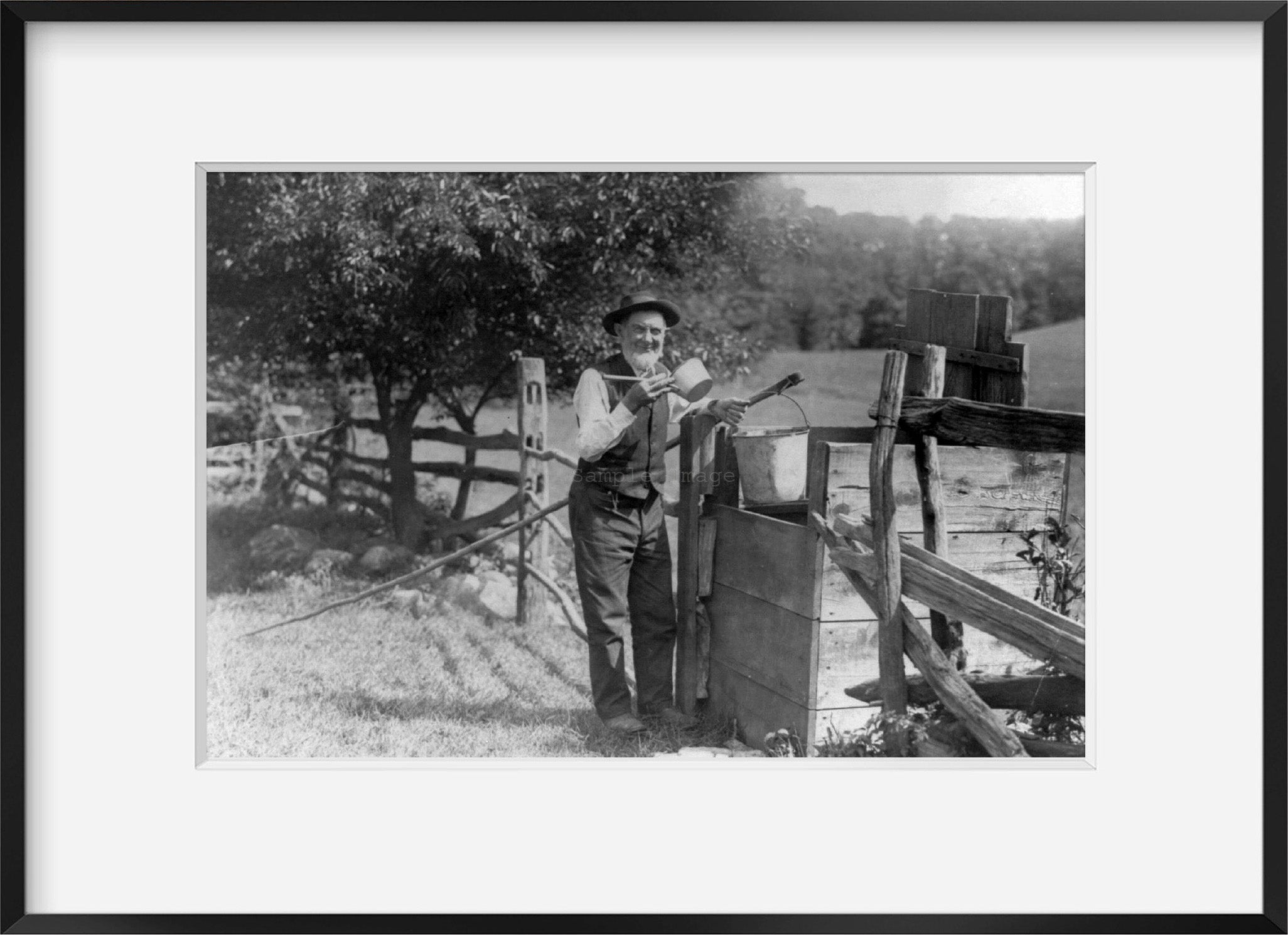 Photo: Old man drinking from dipper at well, c1912, wooden fence, man holding bucke