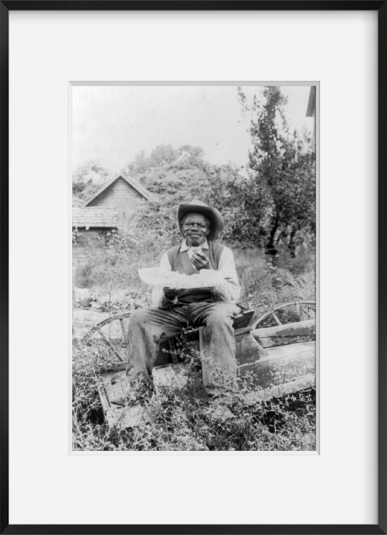 Photo: African American man sitting, eating watermelon, Southern Pines, Moore Count
