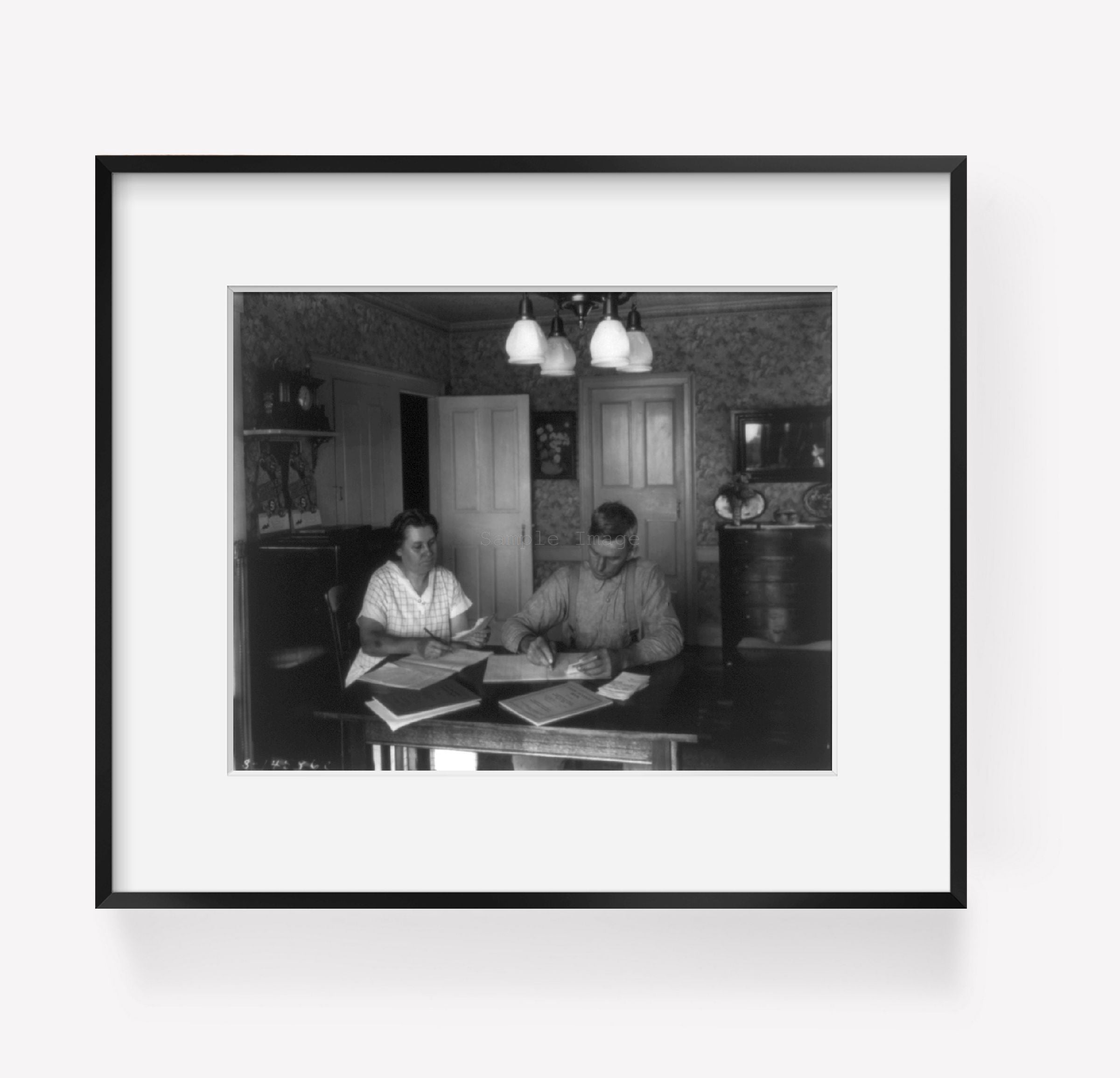 Photo: Farm couple working on bookkeeping, dining room, 1930?