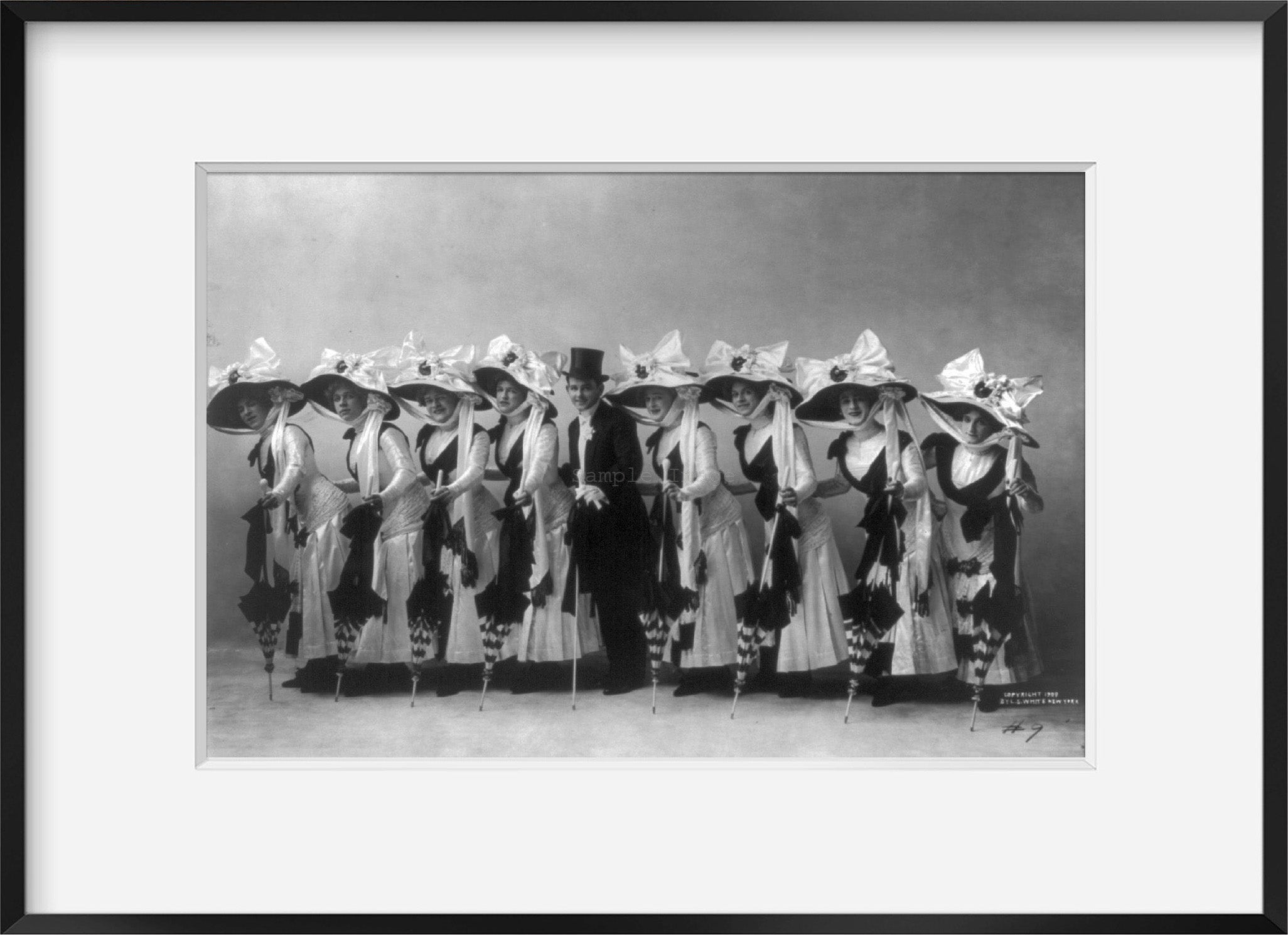 Photo: Line of 8 chorus girls with top-hatted man, c1909