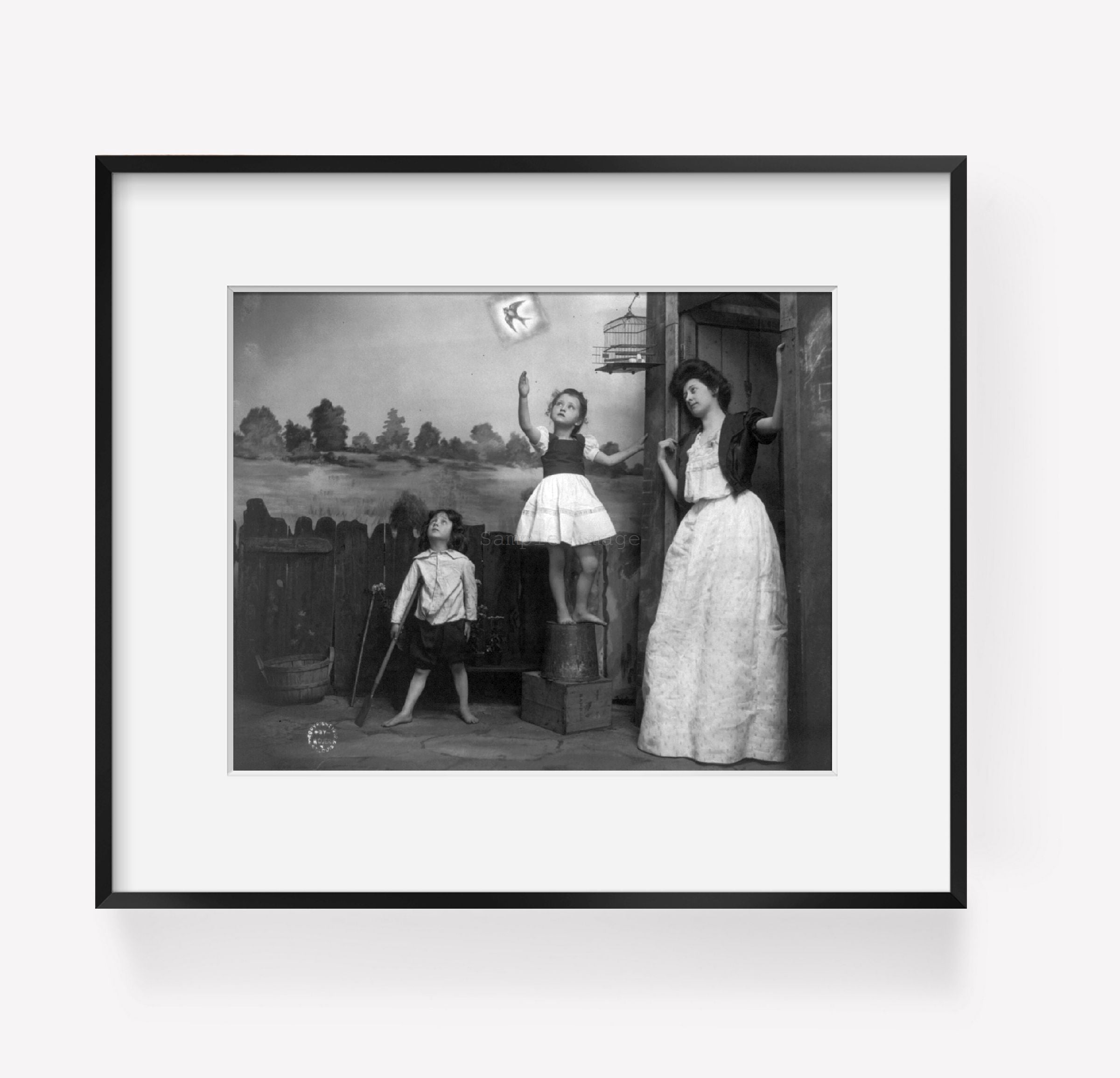 ca. 1900-10 photograph of Woman and 2 children watching bird fly from cage