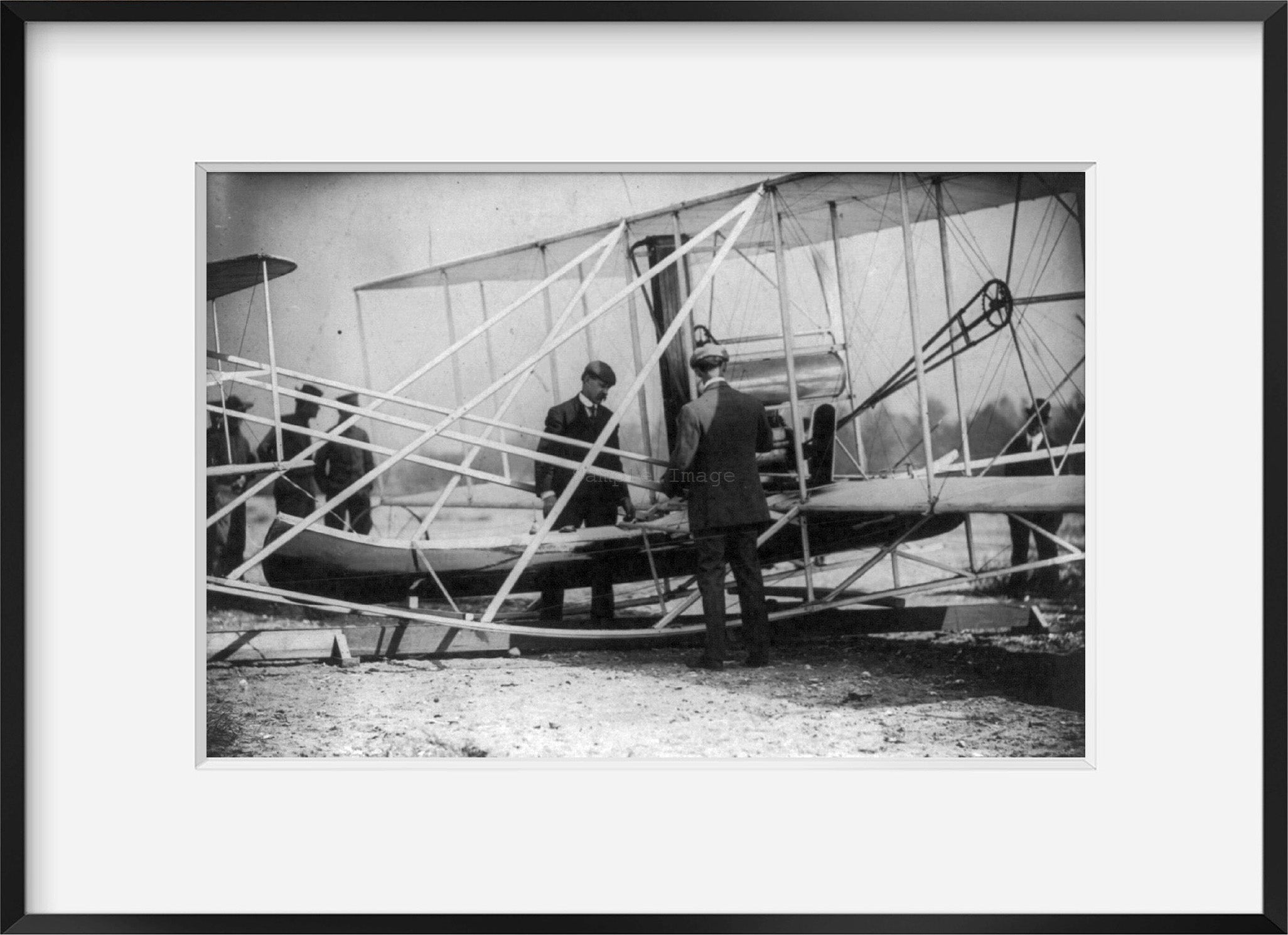 Photo: Wilbur Wright examining canoe attachment, aeroplane before 1st flight over
