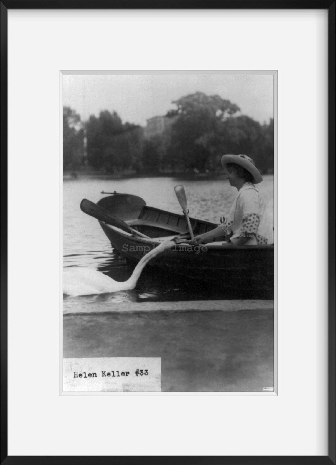 Photo: Helen Keller in a boat by shore, feeding swan, c1913